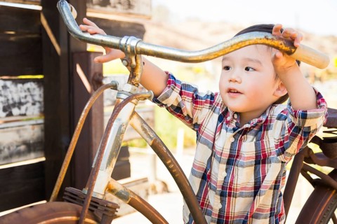 mixed-race caucasian and chinese young boy having fun on the bicycle