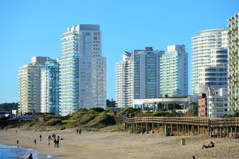 Wooden jetty on the beach in front of high-rise buildings with flats