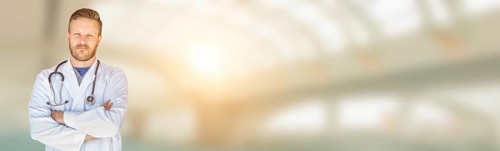 Banner of handsome young adult male doctor with beard inside hospital building