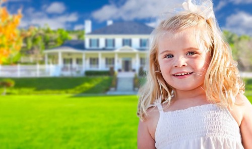 Cute smiling girl playing in front yard of house