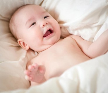 Young mixed-race chinese and caucasian baby boy having fun on his blanket