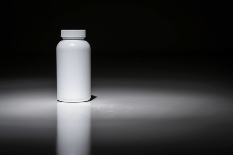 Blank white bottle ready for your text under spot light