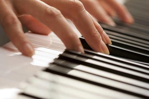 Woman's fingers on digital piano keys