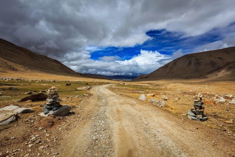 Road in Himalayas with stone cairns. Ladakh