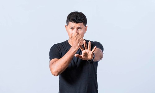 Annoyed man covering his nose