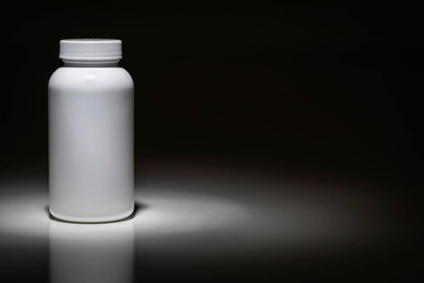 Blank white bottle ready for your text under spot light