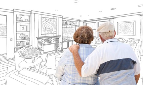 Curious senior couple looking over custom living room design drawing