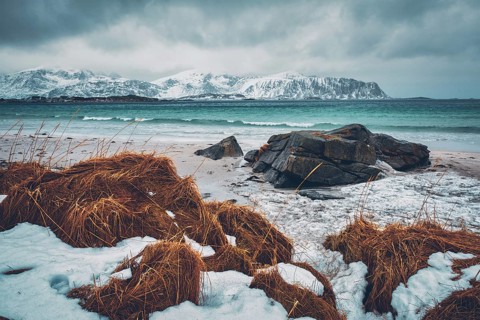 Waves of Norwegian sea on rocky beach of fjord. Ramberg beach