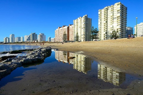 High-rise buildings with flats reflected in the water on the beach