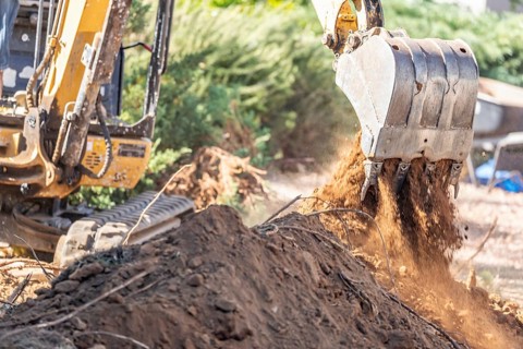 Working excavator tractor digging A trench at construction site
