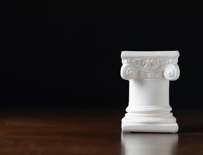 White ionic design column on dark background