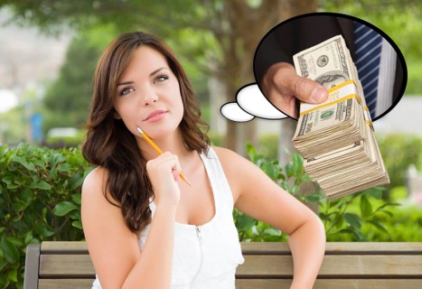 Thoughtful young woman with hand holding stack of money inside thought bubble