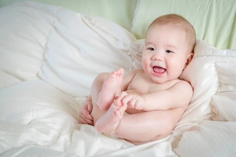 Young mixed-race chinese and caucasian baby boy having fun on his blanket