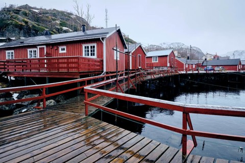 Nusfjord authentic traditional fishing village with traditional red rorbu houses in winter in Norwegian fjord. Lofoten islands