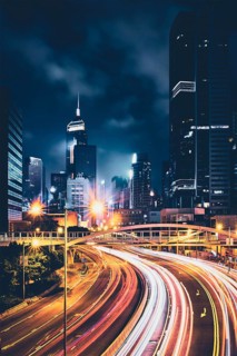Street traffic in Hong Kong at night. Office skyscraper buildings and busy traffic on highway road with blurred cars light trails. Hong Kong