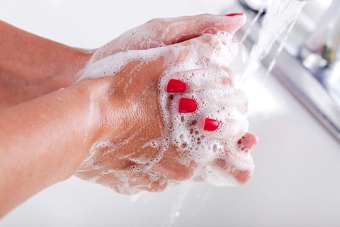Woman thoroughly washing hands in the sink basin