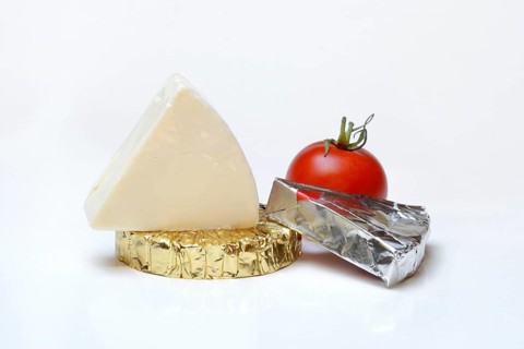 Runder und dreieckiger Schmelzkaese mit Tomate