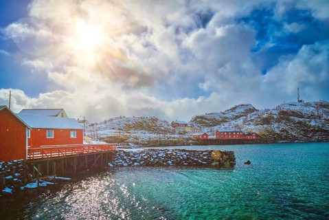 Red rorbu houses of Sakrisoy village with snow in winter. Lofoten islands