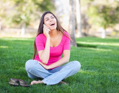 Beautiful young ethnic woman talking on her smartphone outside