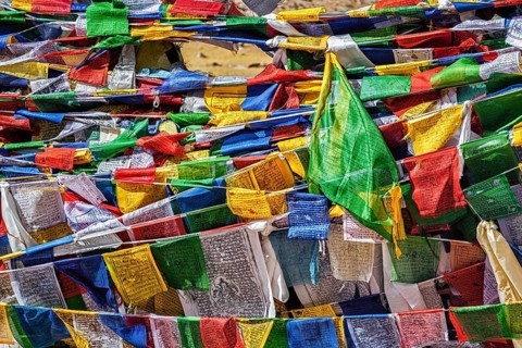 Buddhist prayer flags lungta with mantra Om mani padme hum in tibetan language on Namshang La pass in Himalayas. Ladakh
