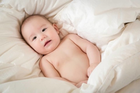 Young mixed-race chinese and caucasian baby boy having fun on his blanket