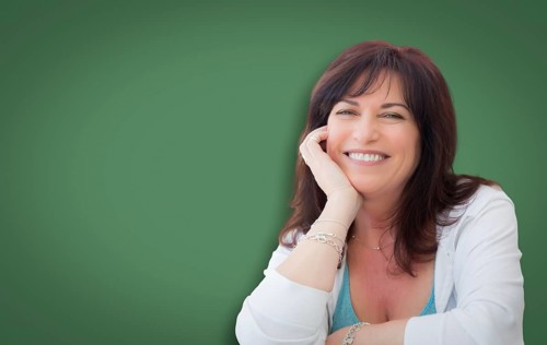 Attractive middle aged woman portrait in front of green chalkboard