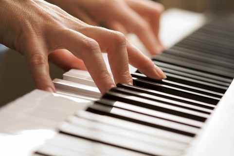 Woman's fingers on digital piano keys