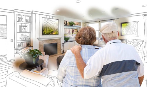 Curious senior couple looking over custom living room design drawing photo combination