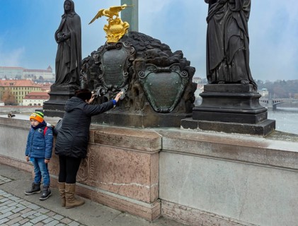 Praying woman with child on Charles Bridge