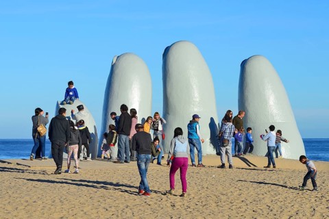 Tourists in front of the sculpture La Mano