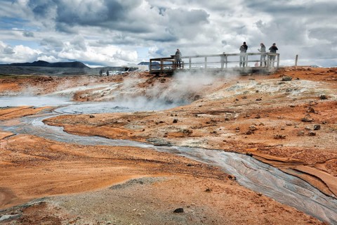 Tourists on viewing platform at steaming mud pot