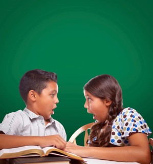 Blank chalk board behind hispanic boy and girl having fun studying together
