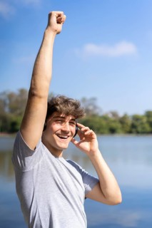 Young man listening to music outdoors with headphones. Expression of happiness