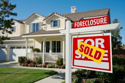 Sold foreclosure home for sale sign in front of beautiful house