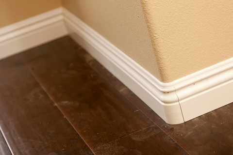 New baseboard and bull nose corners with laminate flooring abstract