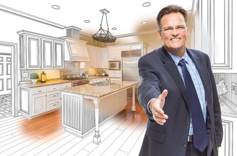 Smiling male agent reaching for hand shake in front of kitchen drawing and photo combination
