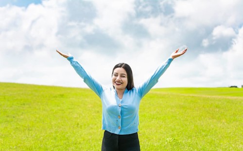 Attractive girl spreading her arms in the field