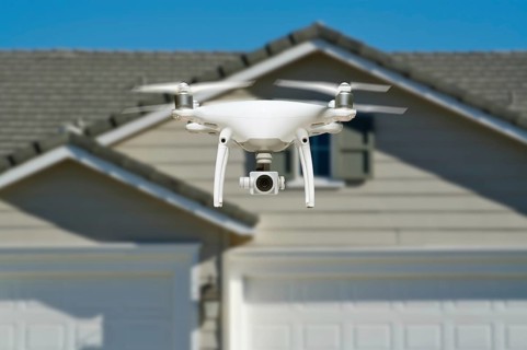 Unmanned aircraft system quadcopter drone in the air near house