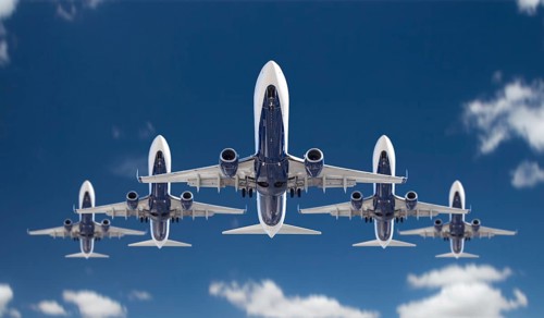 Bottom view of five passenger airplanes flying in formation in the blue sky