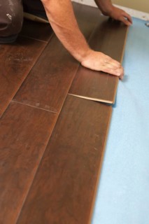Man installing new laminate wood flooring abstract