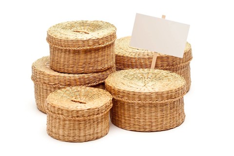 Various sized wicker baskets with blank sign isolated on white