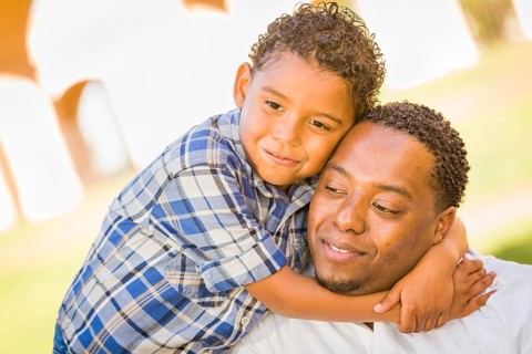 Happy african american father and mixed-race son playing at the park