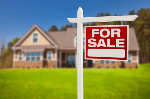Home for sale real estate sign in front of beautiful new house