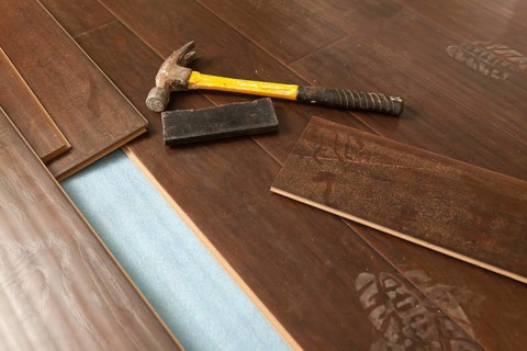 Hammer and block with new laminate flooring abstract