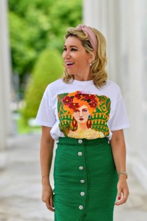 Portrait in einem Park einer huebschen Dame in ihren vierziger Jahren mit langen blonden Haaren. Sie geht auf die Kamera zu und blickt mit ueberraschte Blick zu Seite. Ein gruener langer Rock mit bedr...