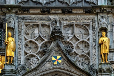 Golden statues and architectural details on the facade above the entrance of the Basilica of the Holy Blood in Bruges