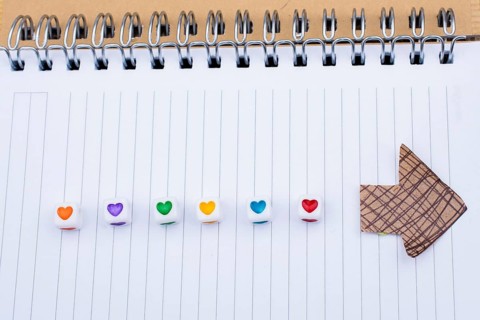 Love cubes and paper arrow on a notebook on canvas