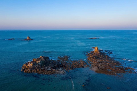 Aerial view of rock formations in the sea in front of the sandy beach Ker Emma shortly in front of sunset