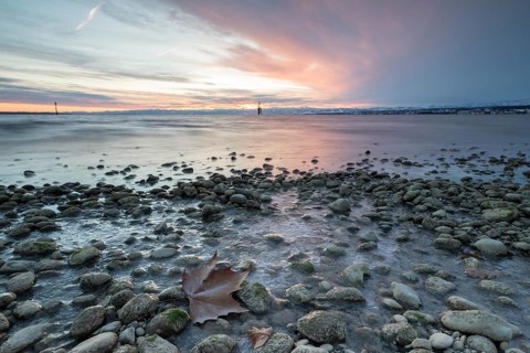Sunrise on a wintry lake in bad weather