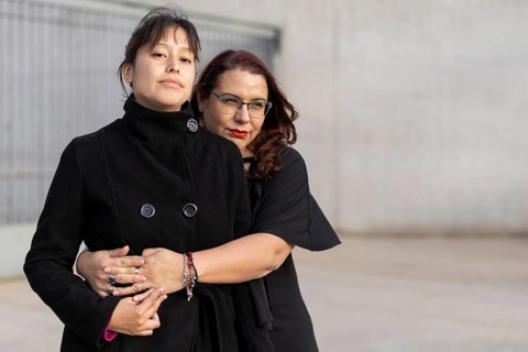 Couple of lesbian women hugging in a park. Copy space